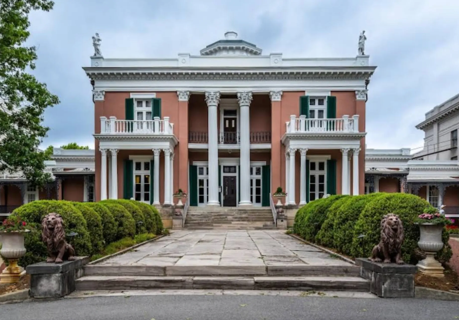 Image: Family standing outside a historic mansion with columns and manicured lawns