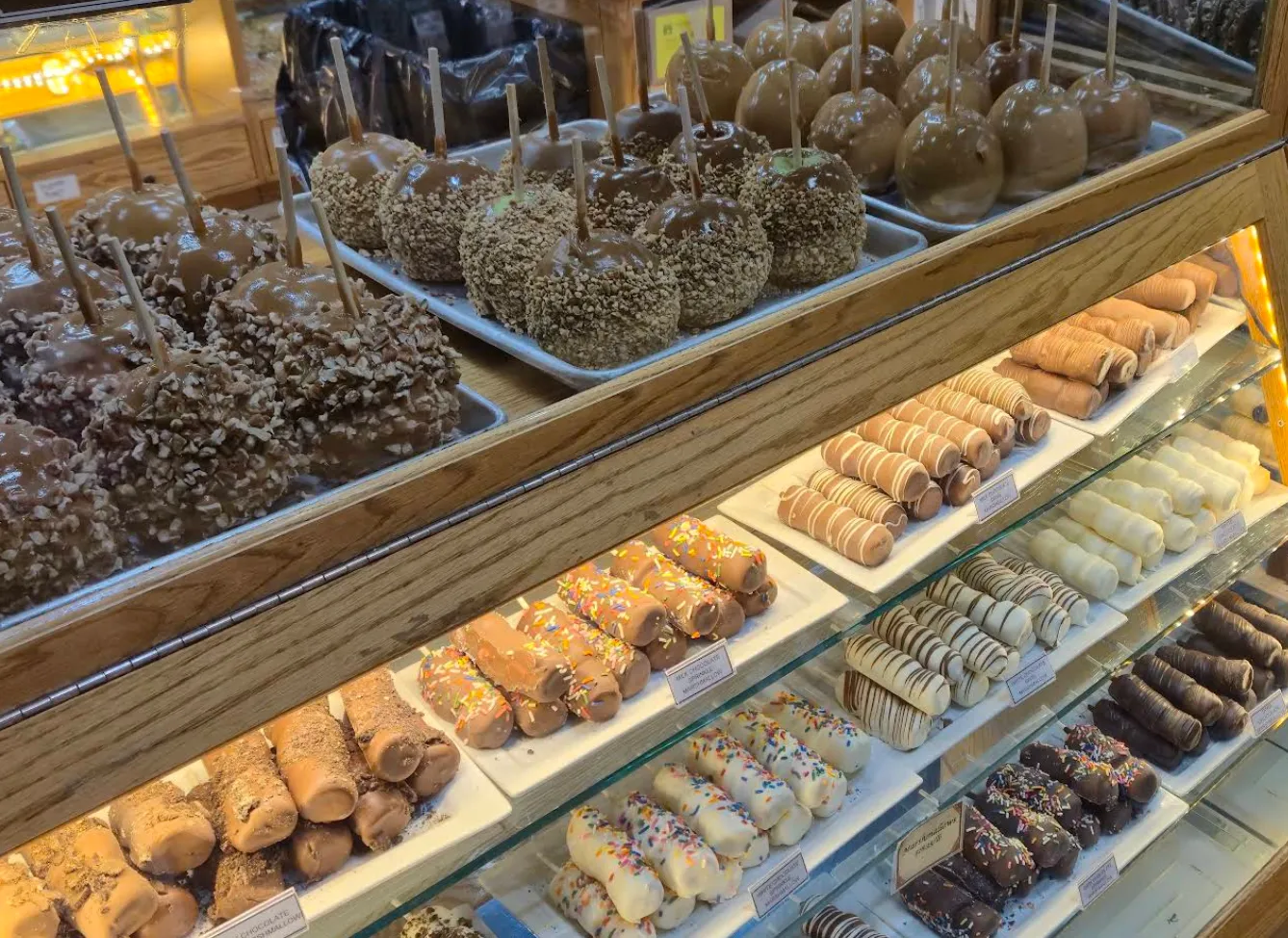 Image: Close-up of a child holding a piece of taffy in a candy shop